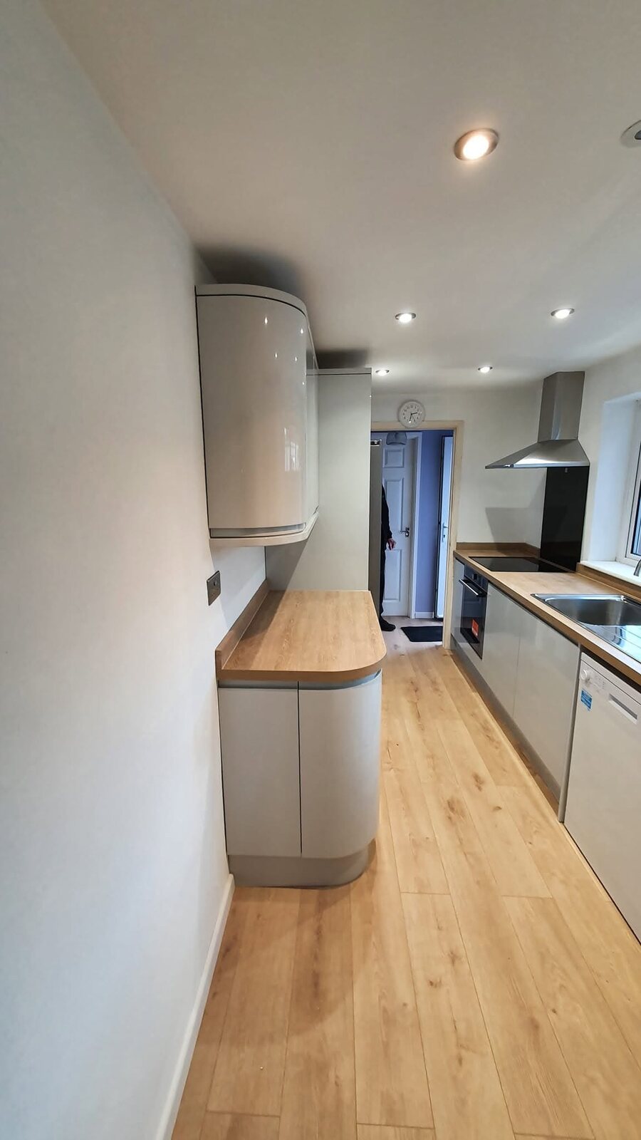 Completed Howdens Gloss Dove Grey kitchen with curved cabinetry and new downlighters